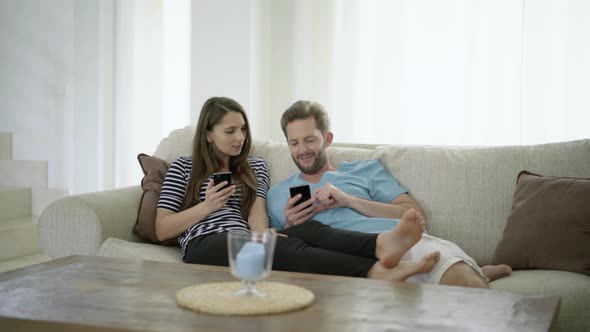 Couple With Smart Phones on Couch