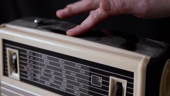 A Female Hand Wipes Dust From the Surface of an Old Receiver with Her Finger alt