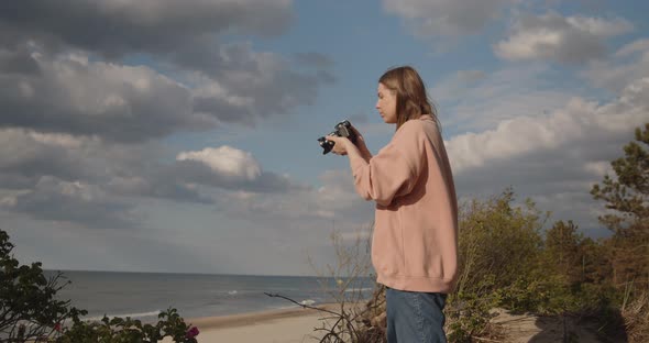 Young Woman Photographer Takes Pictures of the Sea Using Digital Camera