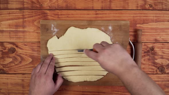 Slicing cut dough to be able to prepare and roll the sweets. alt