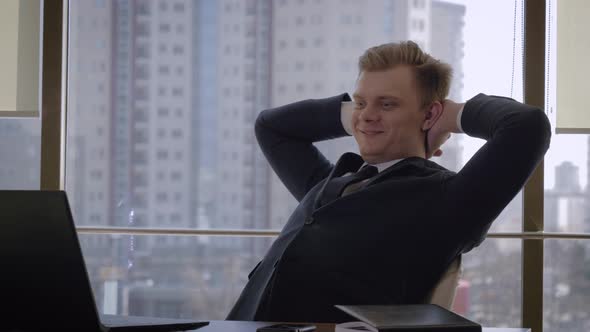 Successful Businessman In Office Removes Hands Behind Head When Achieving Goal alt