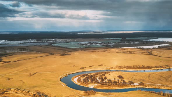Aerial View Of Dry Meadow And Partly Frozen River Landscape In Sunny Autunn Day alt