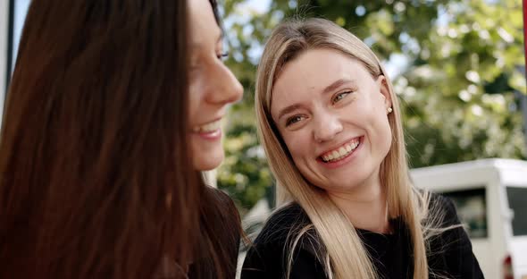 Two Friends Enjoy a Conversation Looking at Each Other in Love Outside Summer alt