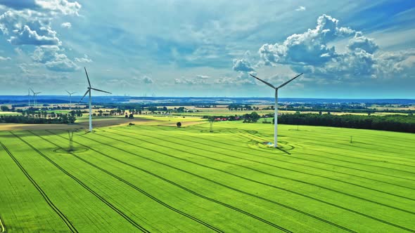 Drone view of wind turbines on green field in summer alt