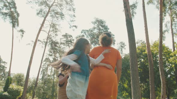 Schoolkids Swinging Teacher with Closed Eyes Around in Circle Outdoors alt