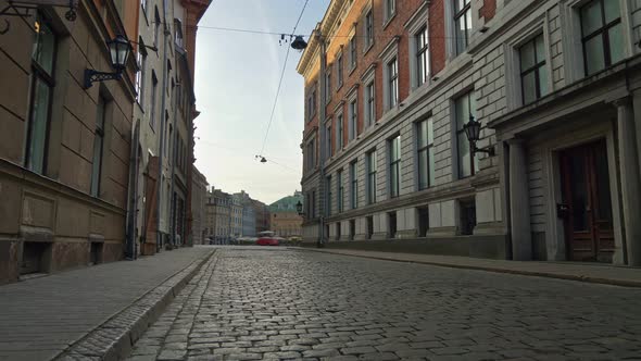 Deserted City Due To Quarantine, Coronavirus Effects. Walking Alone Along the Cobbled Street of Old alt