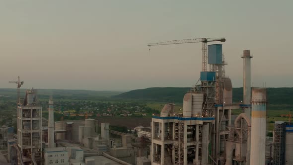 Cement Plant with High Factory Structure at Industrial Production Area at Sunset alt
