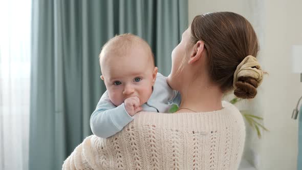 Beautiful Smiling Woman Stroking Her Little Baby Son at Bedroom alt