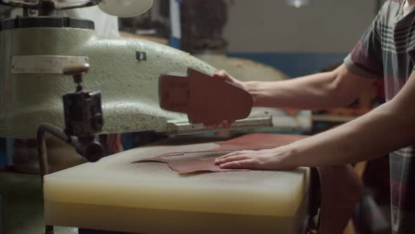 Worker Using Punching Press Machine for Cutting Leather Details Indoor alt