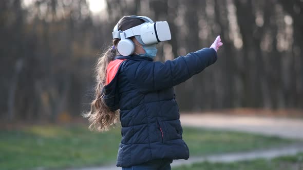 Girl in a medical mask and  virtual digital glasses the virtual reality. child using a VR-headset 
