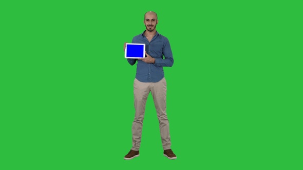 Smiling casual man presenting a tablet with a blank screen alt