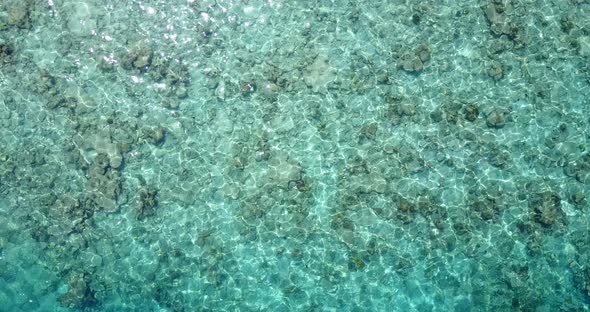 Wide drone copy space shot of a white paradise beach and blue water background in vibrant 4K alt