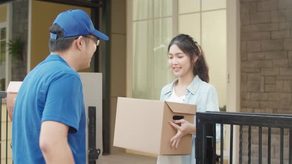 Young postal delivery courier man holding parcel boxes for sending to customer alt