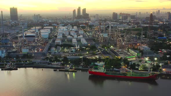 4k aerial view drone of refinery oil petroleum production factory with river reflecting surface sunr alt
