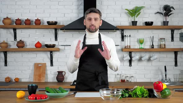 Chef food blogger in apron records online video culinary webinar in home kitchen