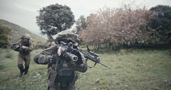 Squad of fully armed commando soldiers during combat in a forest scenery alt