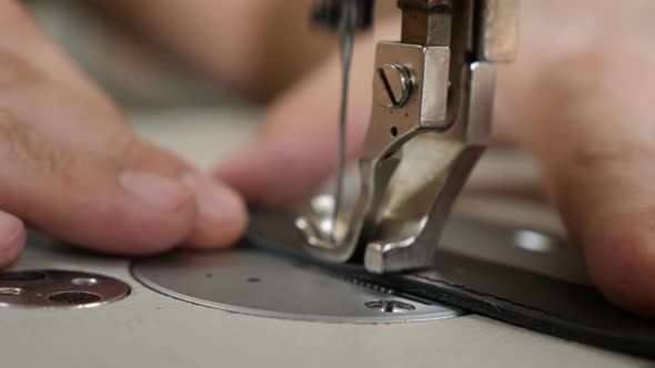 Craft Man at Work. Workshop of Making Leather Bag - Craftsman Stitches the Pouch on Sewing Machine alt