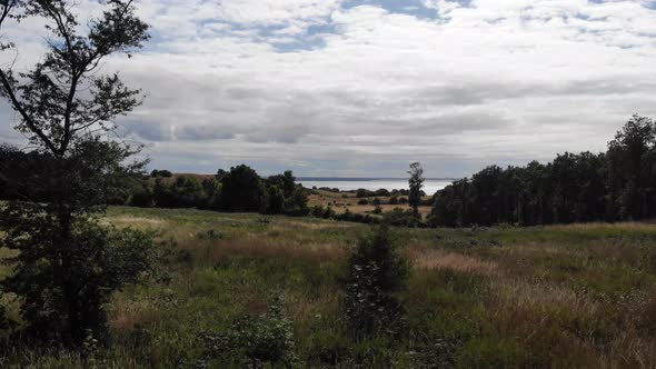 Aerial view of the coastline of Sejerøbugten with hills, fields and ocean. alt