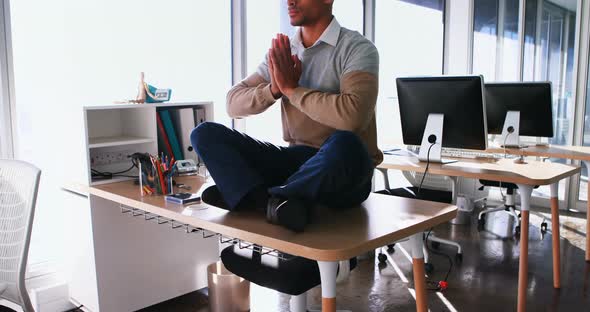 Male executive doing yoga in office 4k alt