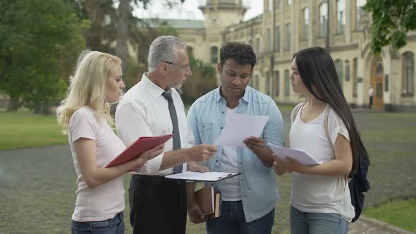 Geography teacher discussing results of last test with group of students alt