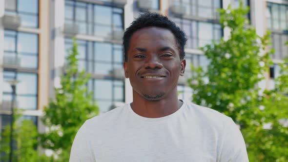 Close Up Smiling Afroamerican Man Looks Camera on Background Modern Building alt