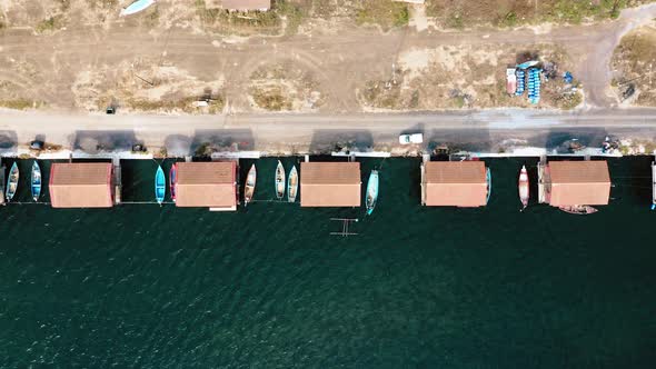Top view of fishing huts with moored boats. alt