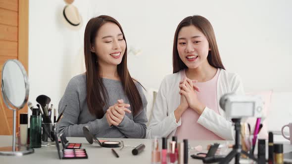 Pretty Asian female friend beauty influencers greeting the audiences while recording viral video