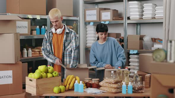 Social Workers Preparing Donation Boxes at Warehouse alt