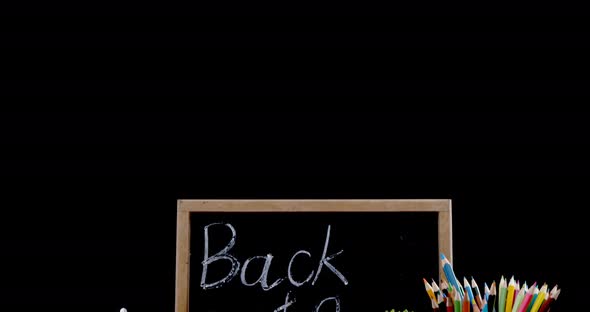 Pot plant and digital tablet with school supplies on table alt