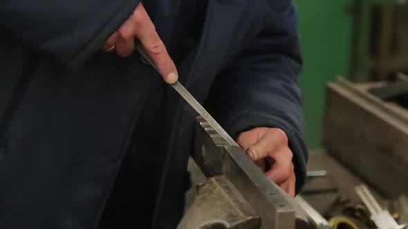 Locksmith Files a Large Part in a Vise. alt