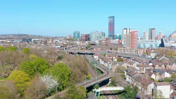 Drone shot towards central Croydon passing over green tram alt