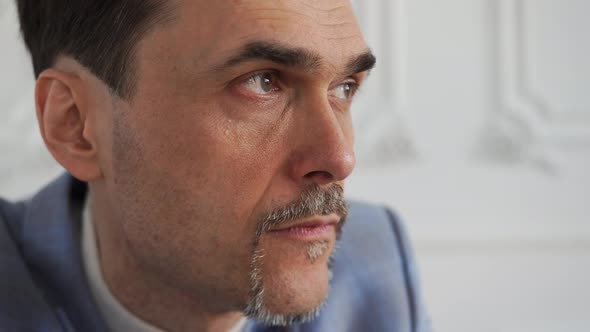 Business Entrepreneur Looking Out the Window at the Sun with a Serious Look alt