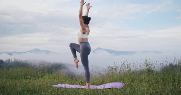 Fit Young Woman Meditating Among Nature alt