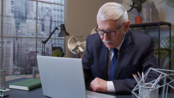 Concentrated Senior Business Man Using Laptop Sits at Office Desk Workplace Web Designer Online Work alt