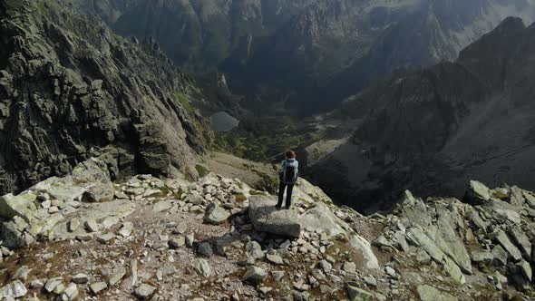 Girl Hiker Standing at the Edge of a Cliff Overlooking the Valley of Tatra Mountains