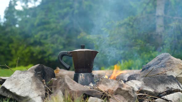 Coffee is Prepared in a Geyser Coffee Maker on a Campfire in the Forest alt