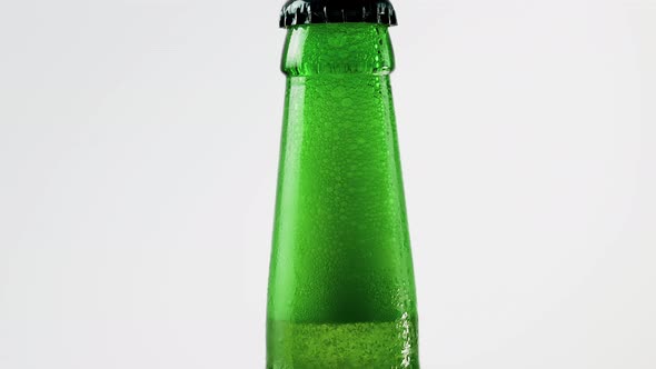 Neck Of A Beer Bottle With Beer Close Up On A White Background, Foamy Beer Inside The Bottle. alt