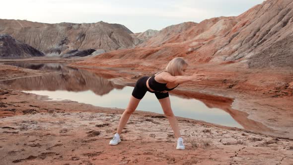 Woman working out on lifeless dried locality