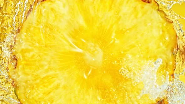 Super Slow Motion Shot of Splashing Water on Rotating Pineapple Slice at 1000Fps. alt