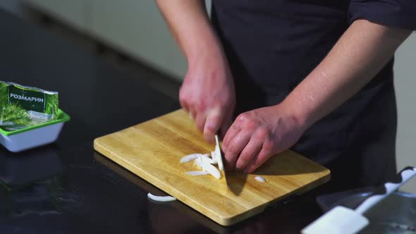 The cook cuts the onion alt