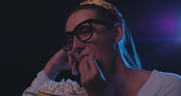 Disappointed woman watching a boring movie at the cinema