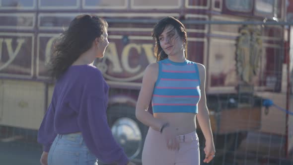 Two Young Women Talk and Dance Around on Roller Skates Half Body Shot alt