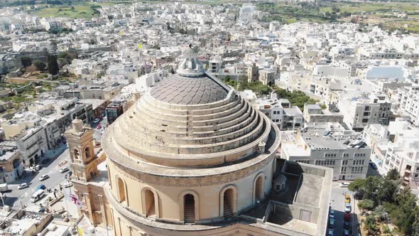 Aerial 4k footage flying over the Mosta Rotunda Dome in Malta and revealing the surrounding city alt