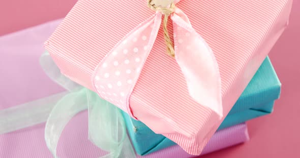 Gift boxes with happy mother day tag against pink background alt