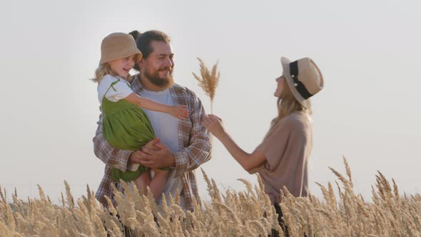 Caring Father Bearded Man Stands in Field in Nature Holding Little Beloved Daughter Girl Child Kid alt