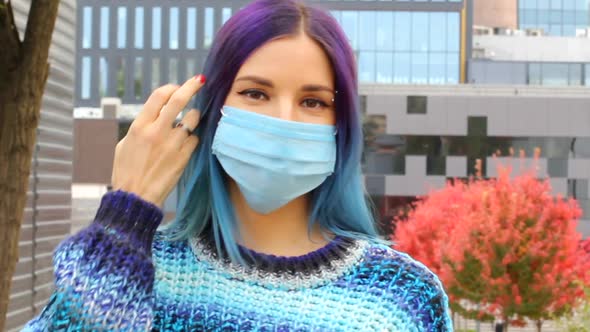 Young woman with blue hair in Protective medical Mask. COVID-19 and healthcare