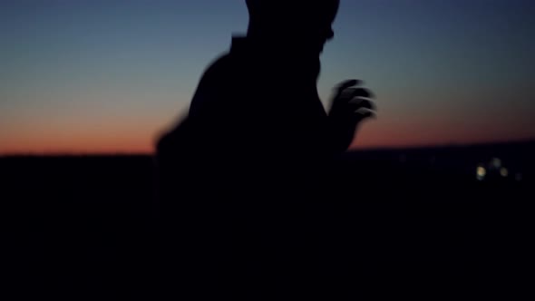 Runner In Sportswear Preparing Triathlon And Workout At Evening. Running Man Silhouette Workout. alt