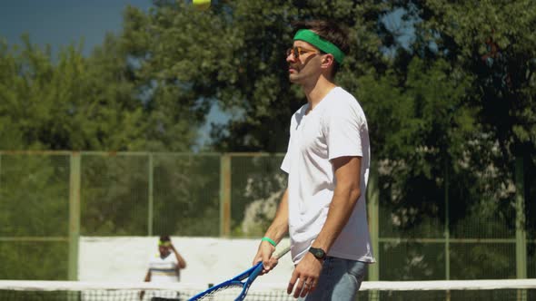 Sportsman Juggling Tennis Ball on Racket