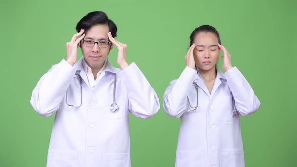Young Asian Couple Doctors Having Headache Together