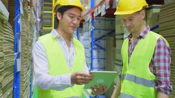 Group of diversity male workers wearing safety work helmet and vest working in industrial warehouse. alt